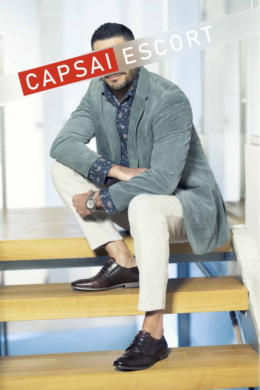 Carlos im grauen Sakko auf einer Holztreppe